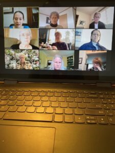 A group of individuals participating in a video conference call viewed on a laptop screen.